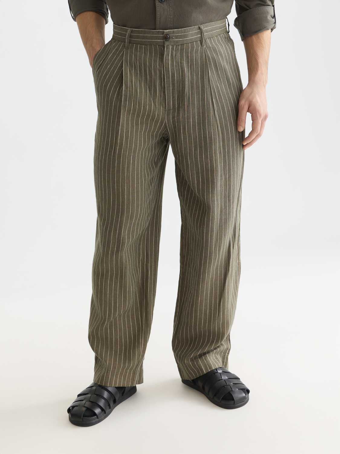 Pleated pinstriped Scotch & Soda chino pants on a model, featuring a tailored fit and classic design.
