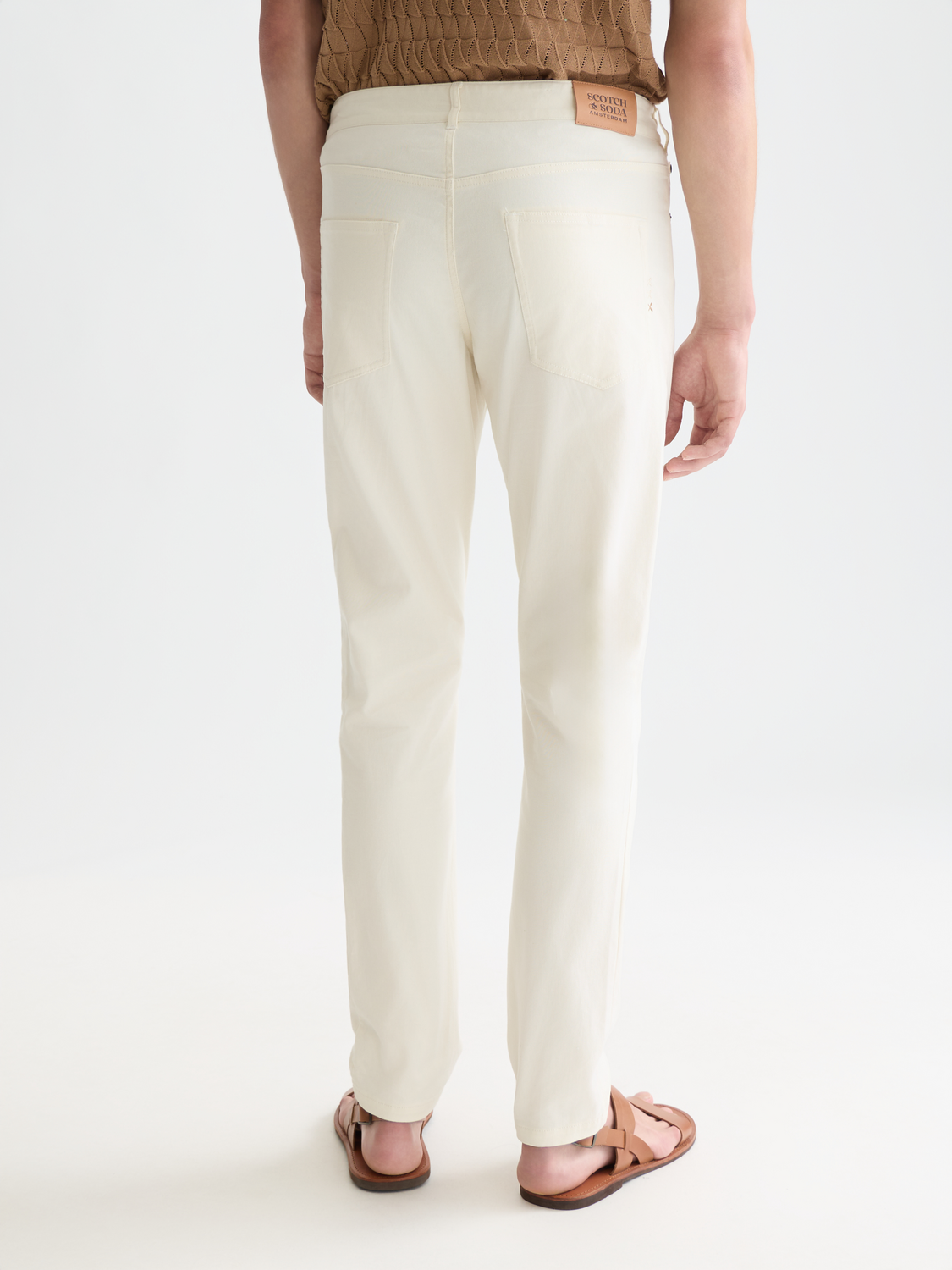 SCOTCH & SODA Ralston slim-fit 5-pocket pants shown from the back in dark fabric with stitching details.