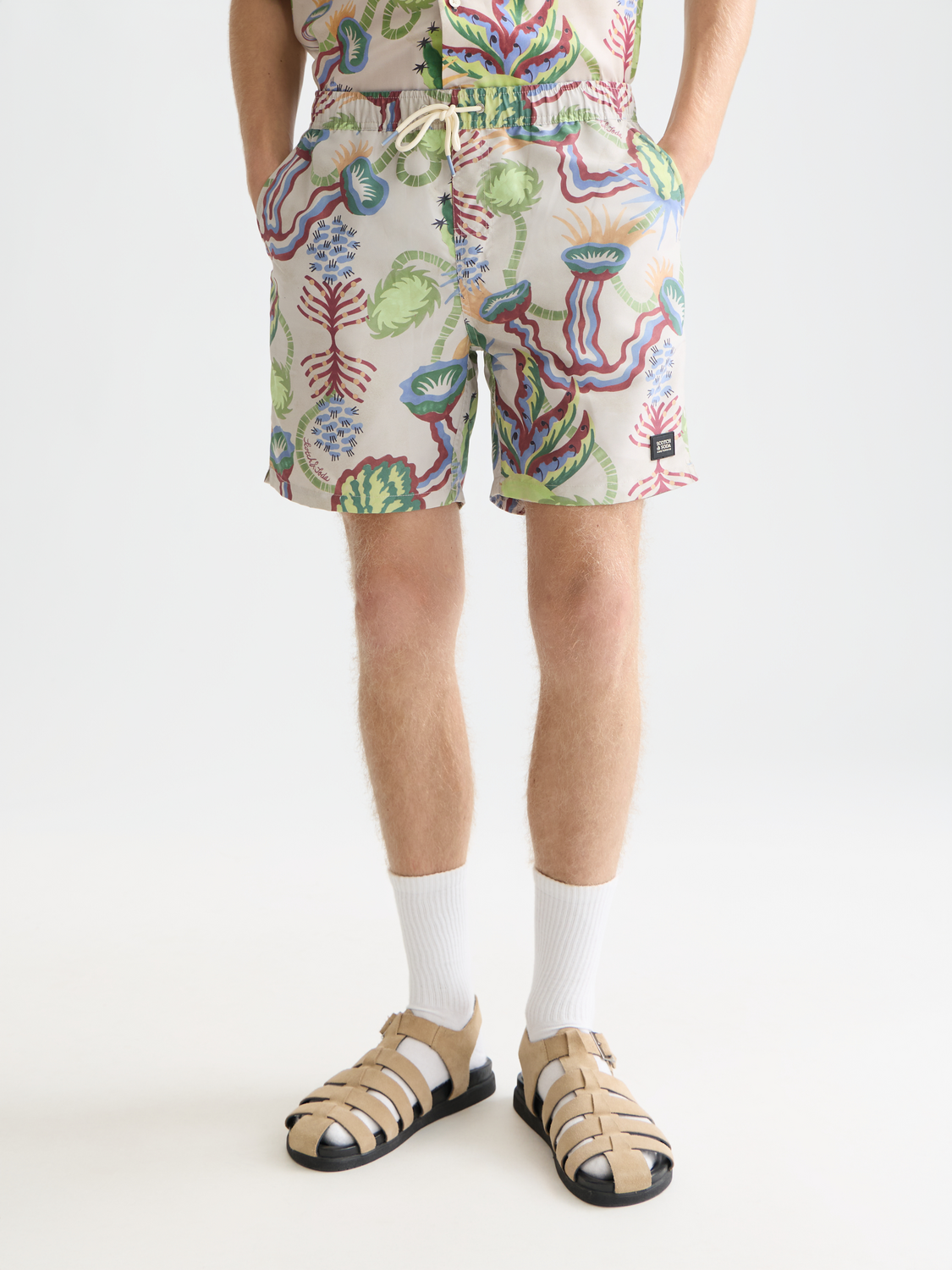 Printed SCOTCH & SODA swimshorts with vibrant tropical pattern, lightweight fabric, and elastic waistband.