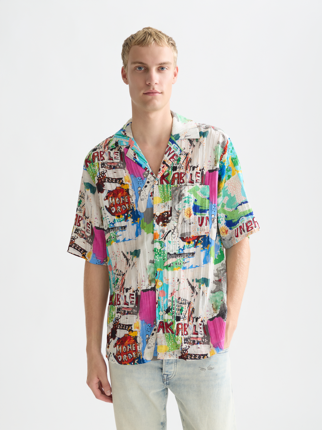 Short-sleeved shirt by Scotch & Soda featuring a S&S x Basquiat printed design with vibrant artwork on front.