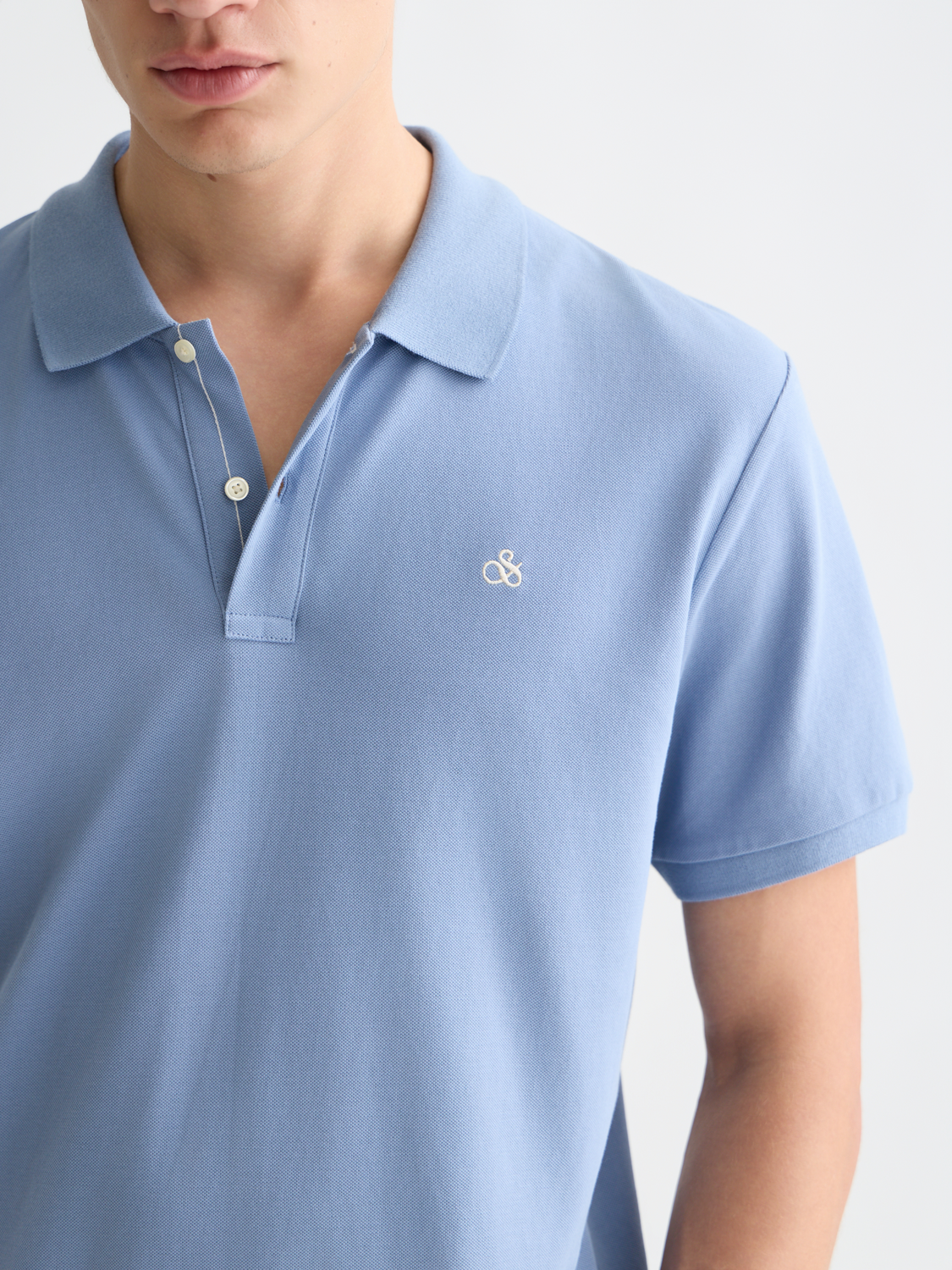 Navy Scotch & Soda logo pique polo shirt with a classic collar and short sleeves, displayed on a plain background.