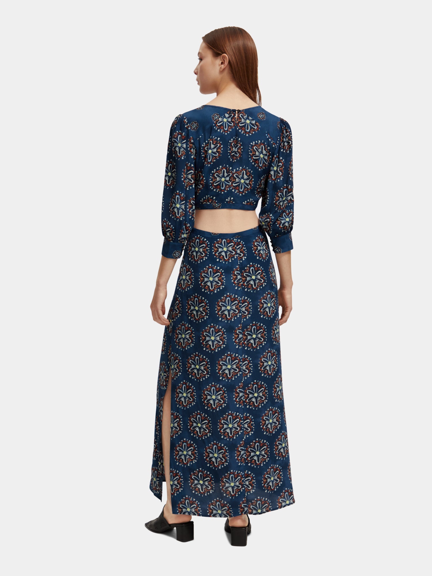 Black Scotch & Soda cut out maxi dress with a flowing silhouette and stylish cut-out details, shown on a model.