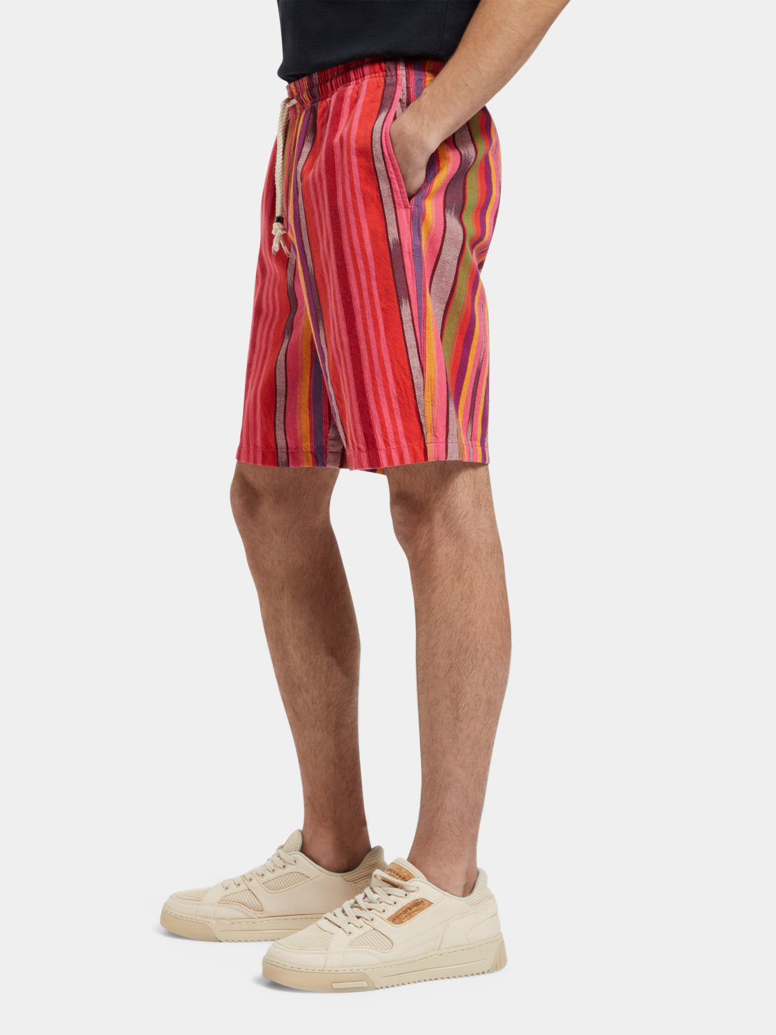 Striped Oxford shorts by Scotch & Soda shown on a model, featuring a casual fit and classic pattern in a natural outdoor setting.