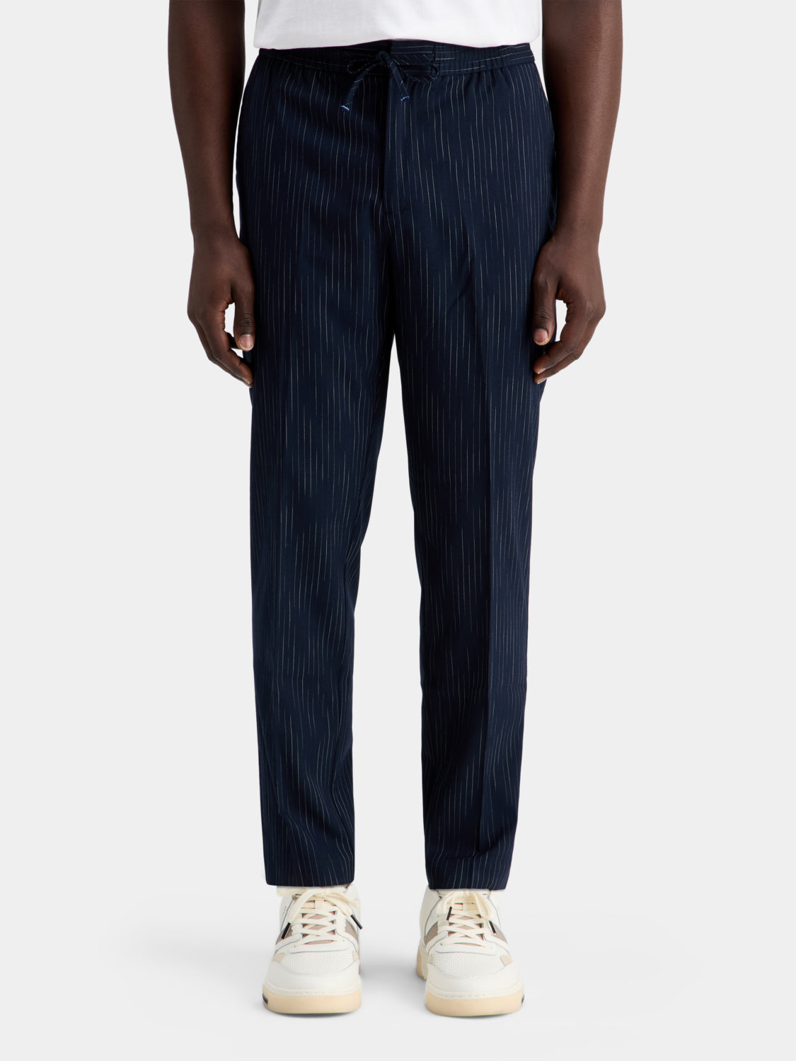Scotch & Soda Finch tapered fit pants in dark fabric, shown on a model, with a focus on the slim, tailored style and waistband.