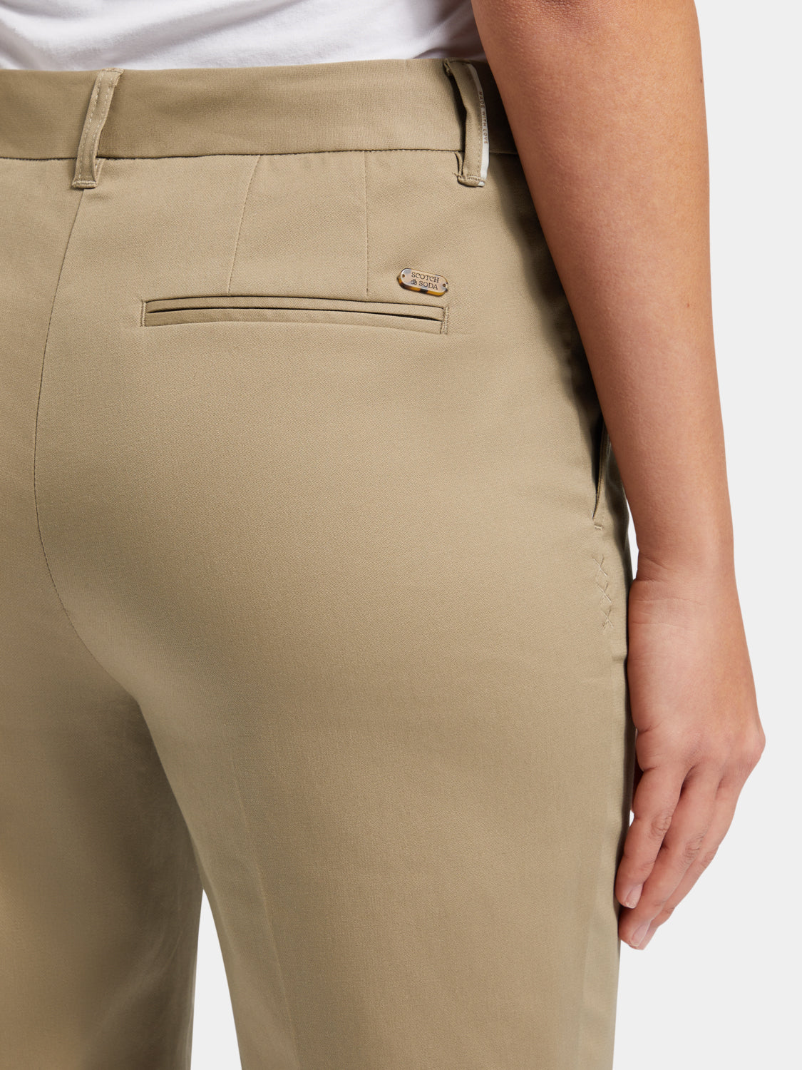 Scotch & Soda Abbott tapered chinos in neutral fabric, shown folded with front pockets visible and tailored fit.
