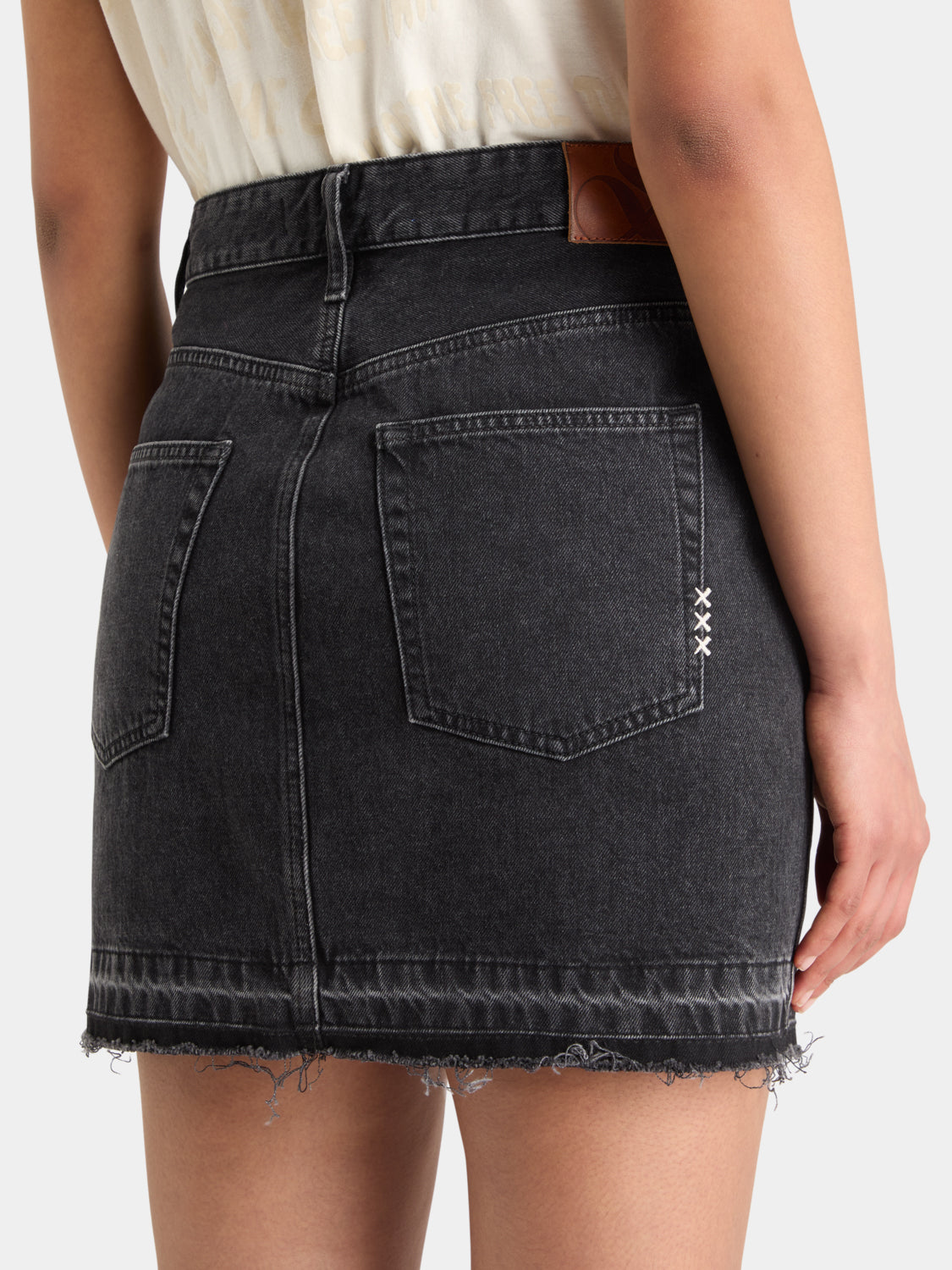 Scotch & Soda cargo denim mini skirt with side pockets and frayed hem, styled on a model.