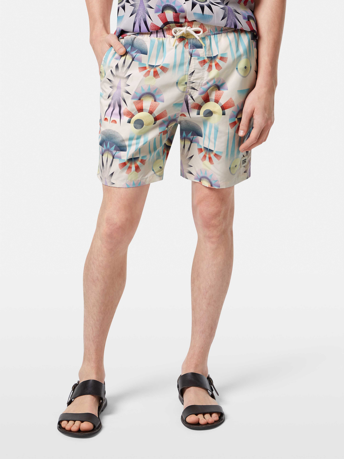 Printed SCOTCH & SODA swimshorts with vibrant pattern, showcased on a model ready for beach or pool.