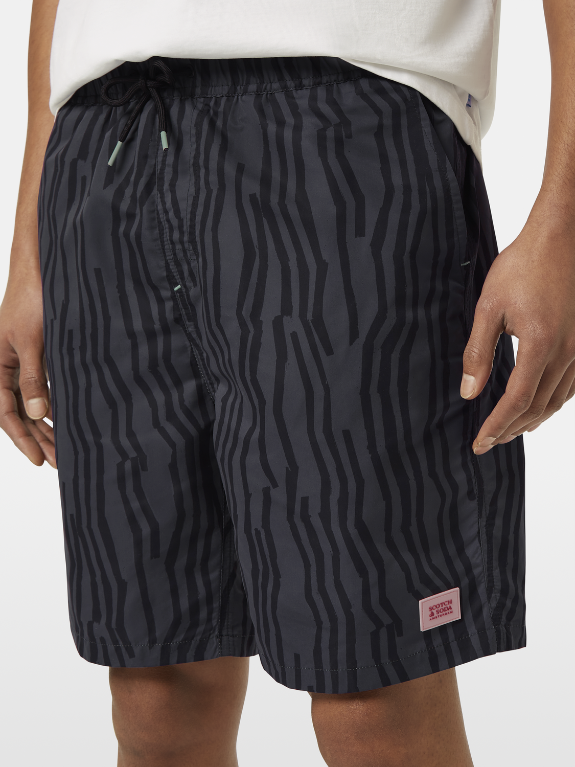 Printed Scotch & Soda swimshorts with vibrant tropical pattern, showcasing the lightweight fabric and comfortable fit.