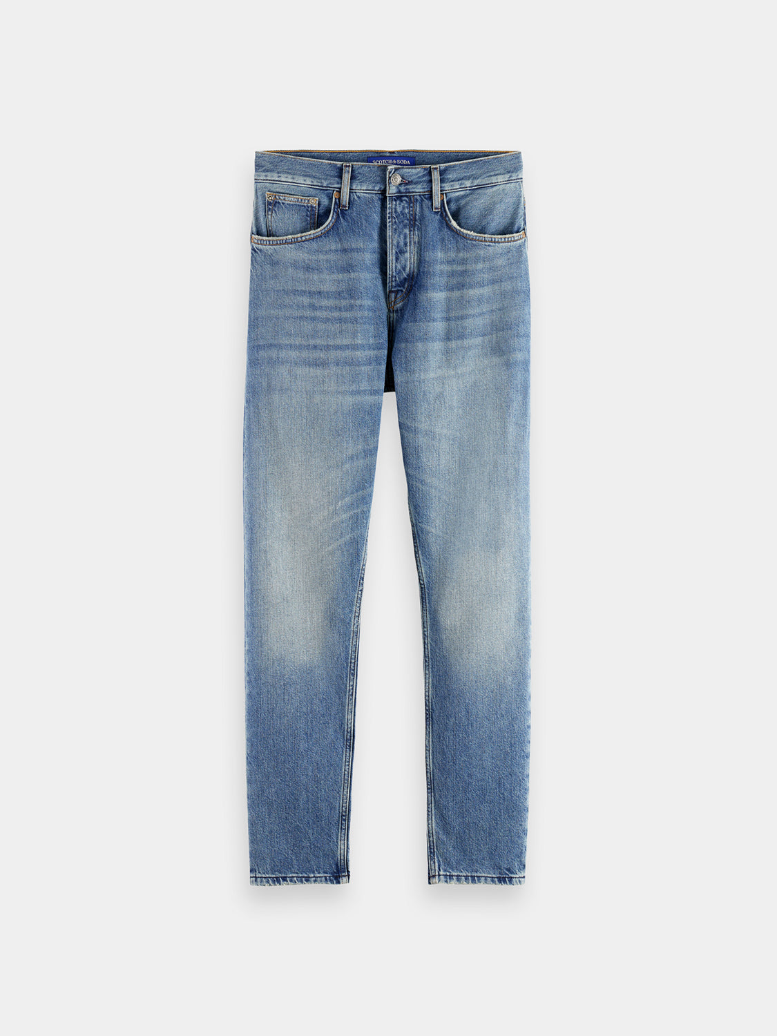 Scotch & Soda Dean tapered denim jeans showing slim fit design and classic blue denim fabric with visible stitching.