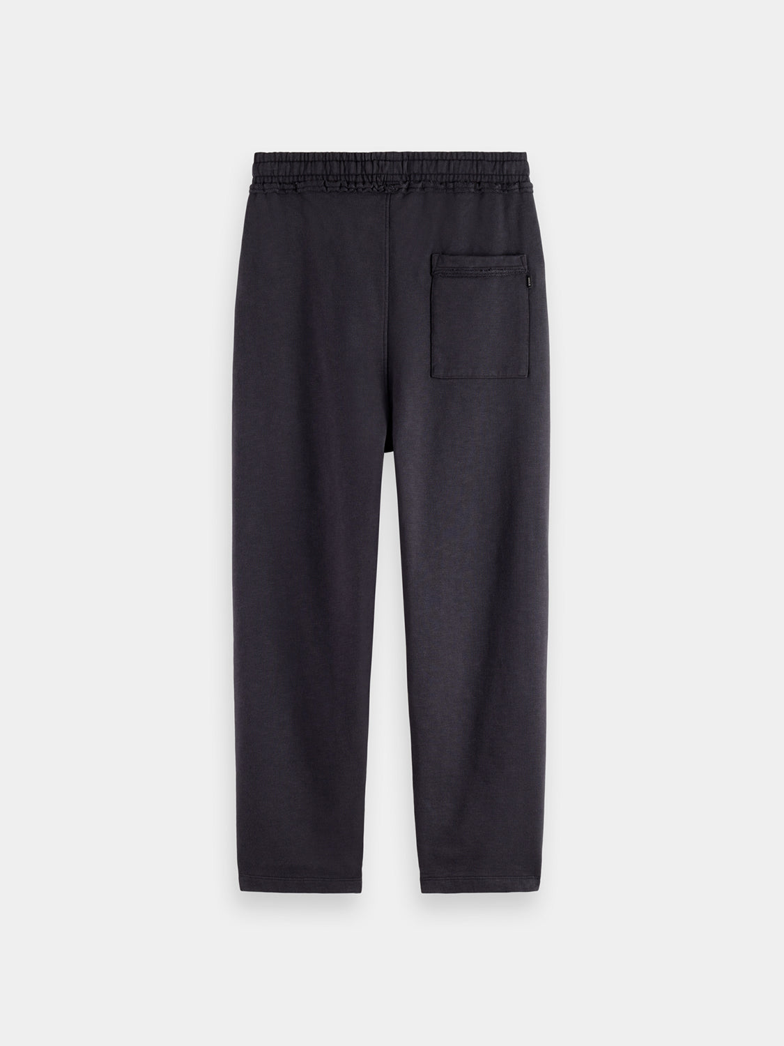 Black Scotch & Soda tapered sweatpants with relaxed fit and elastic waistband, shown from the back on a hanger.
