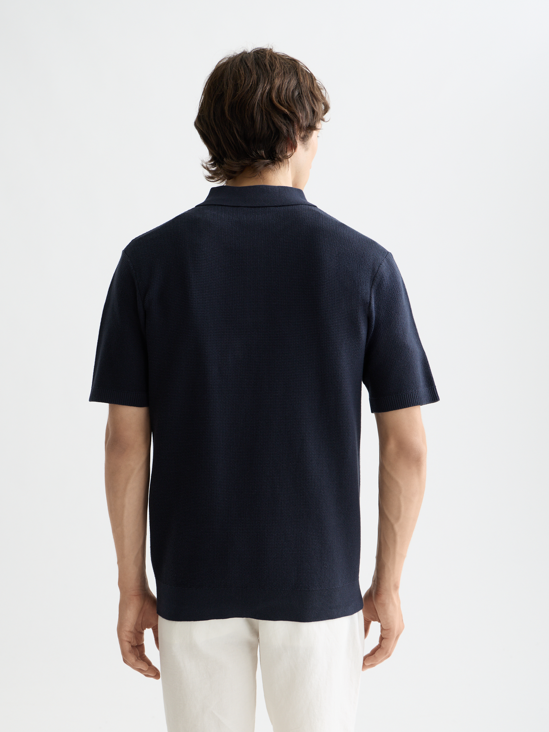Black knitted polo shirt by Scotch & Soda featuring a classic collar and ribbed cuffs.