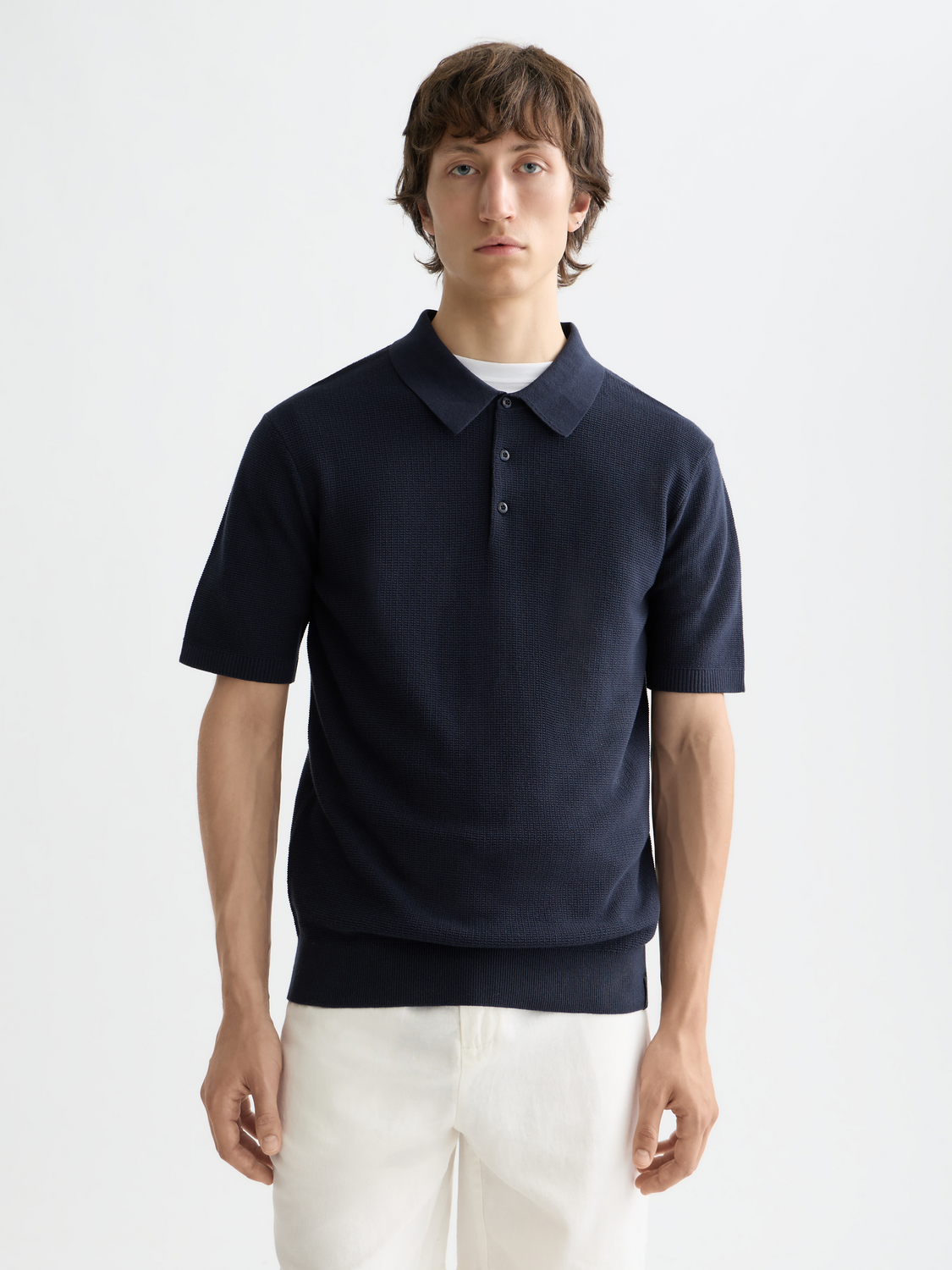 Knitted polo shirt by Scotch & Soda featuring a classic collar, button placket, and textured knit fabric in a neutral tone.