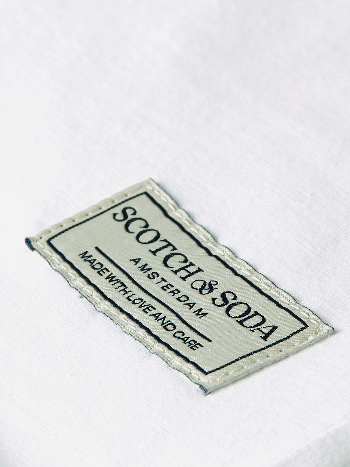 Raw-edged SCOTCH & SODA short sleeve t-shirt, casual design with distressed hem, displayed on a neutral background.