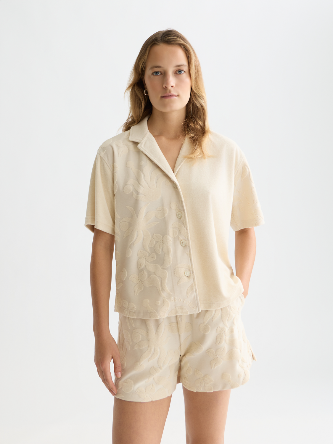 Light beige Scotch & Soda short-sleeved towelling shirt with a relaxed fit and subtle texture, displayed on a hanger.