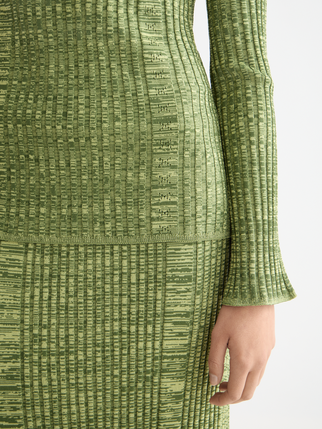 Ribbed knitted SCOTCH & SODA pullover, close-up of textured knit fabric and ribbed cuffs on a neutral background.