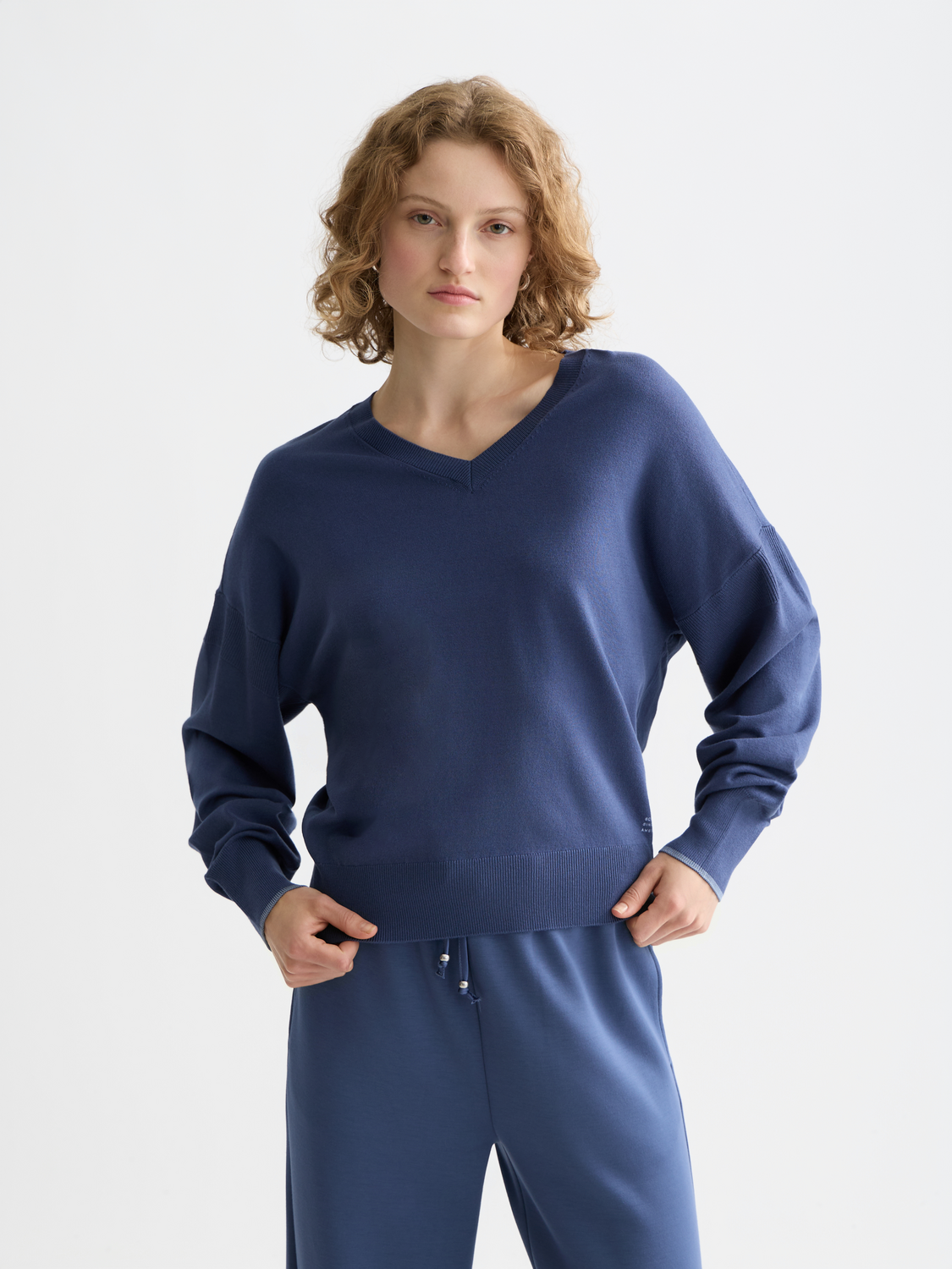 Scarlet V-neck relaxed-fit Scotch & Soda knitwear pullover worn by a model, showcasing comfortable casual style.