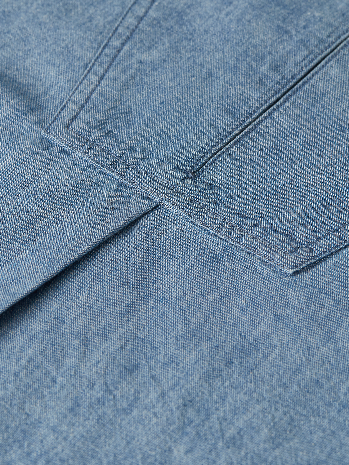 Denim bib shirt from Scotch & Soda, woven top with adjustable straps and front pocket, styled casually.
