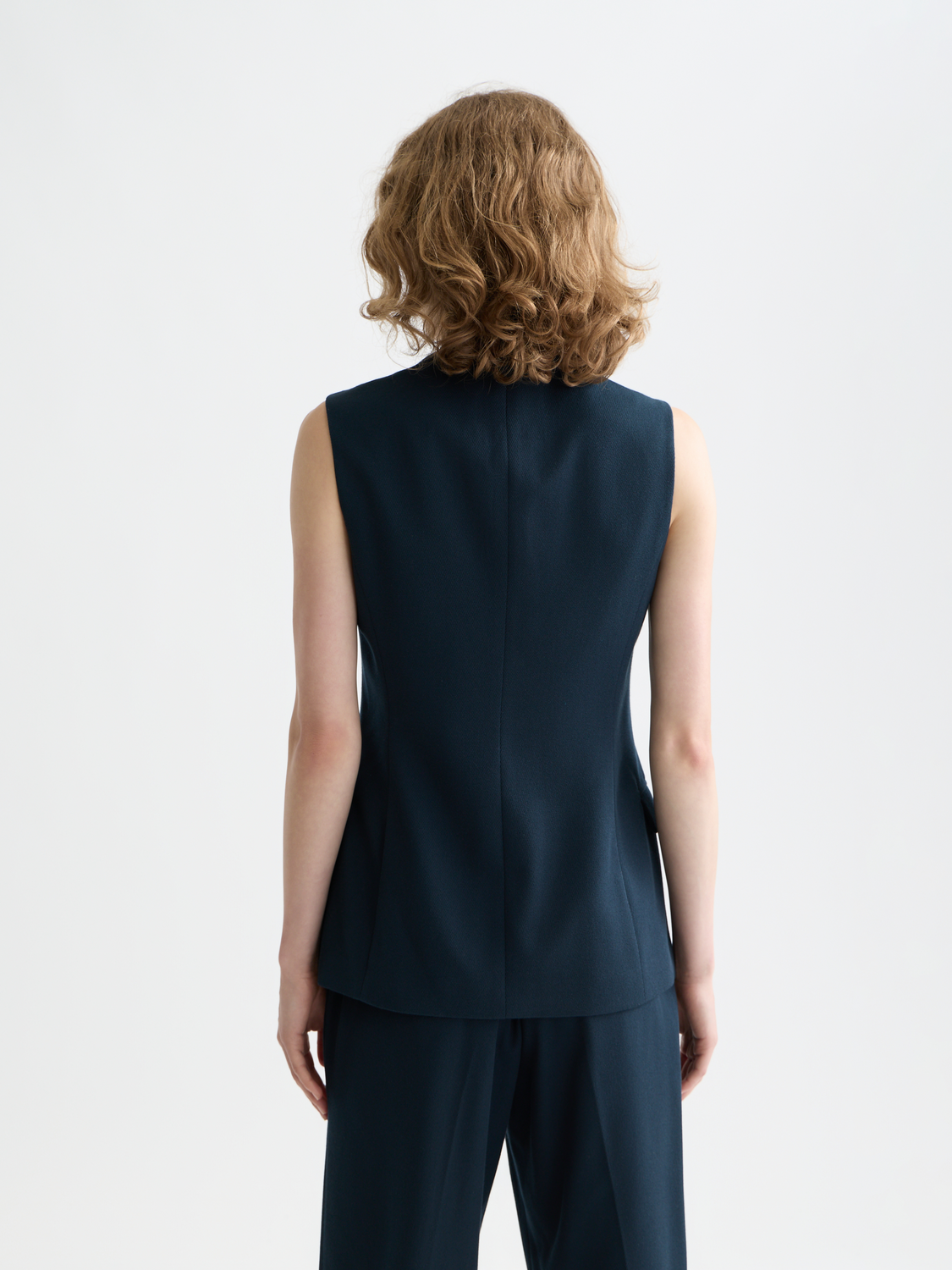 Tailored Scotch & Soda gilet in dark red with front pockets and button closure, shown from the back.