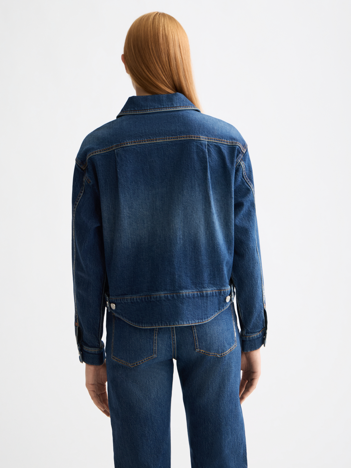 Cropped denim jacket by Scotch & Soda displayed on a model, showing classic blue wash, button front, and rolled cuffs.