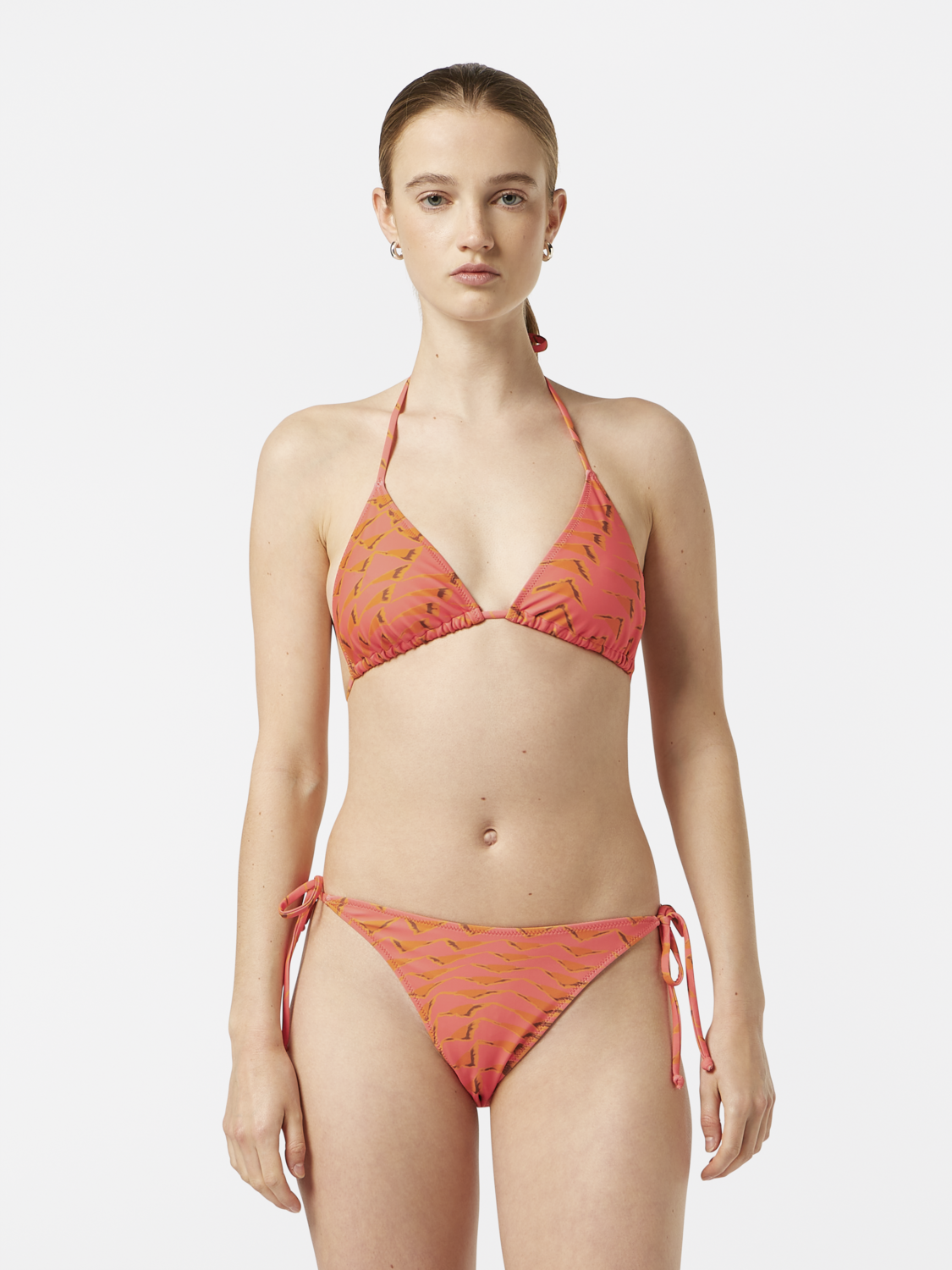 Printed bikini top from Scotch & Soda swimwear featuring vibrant floral patterns and adjustable straps on a model.