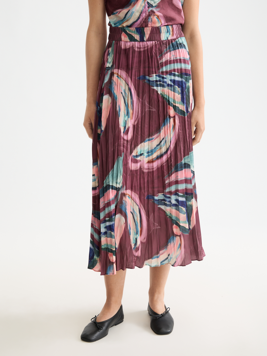 Crinkle pleated midi skirt by Scotch & Soda, showing the flowy fabric and detailed pleats in a neutral tone.