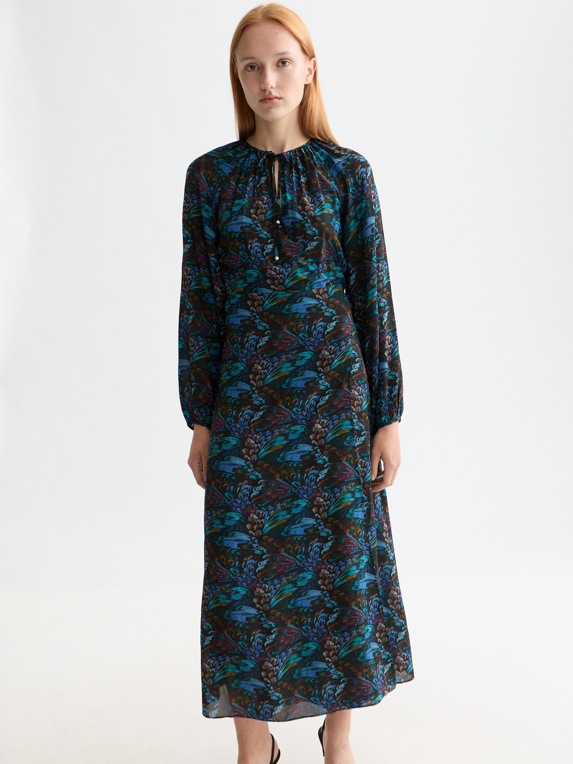 Scotch & Soda midi wrap dress featuring a floral pattern, long sleeves, and a fitted waist on a model.