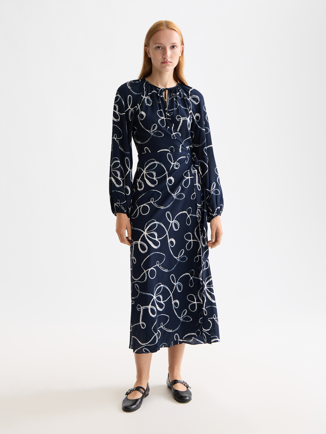 Scotch & SODA midi wrap dress with floral pattern, fitted waist, and long sleeves, displayed on a model.