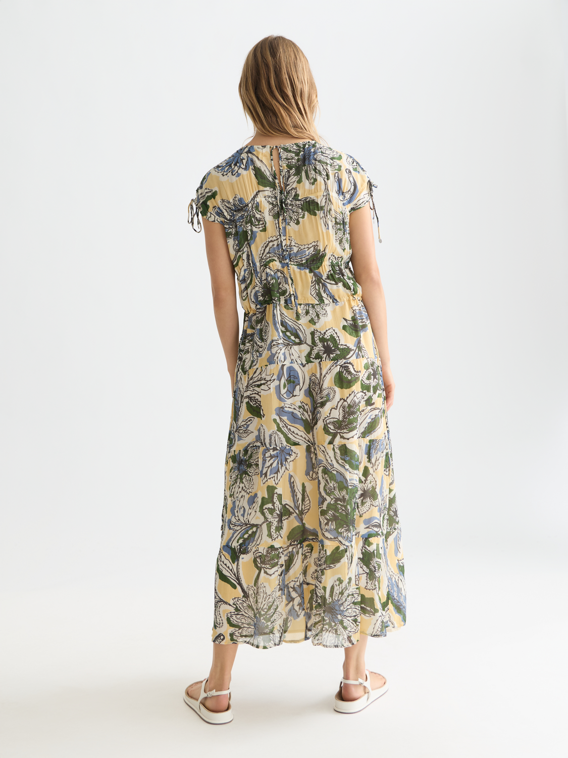 Printed maxi dress from Scotch & Soda featuring a flowy silhouette and vibrant floral pattern, back view.
