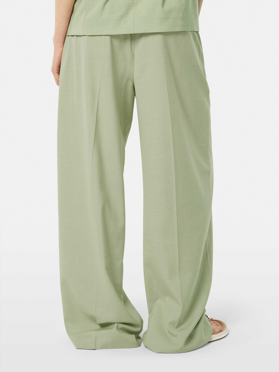Wide-fit rose-colored pants by Scotch & Soda, shown from the back, featuring relaxed fit and stylish design details.