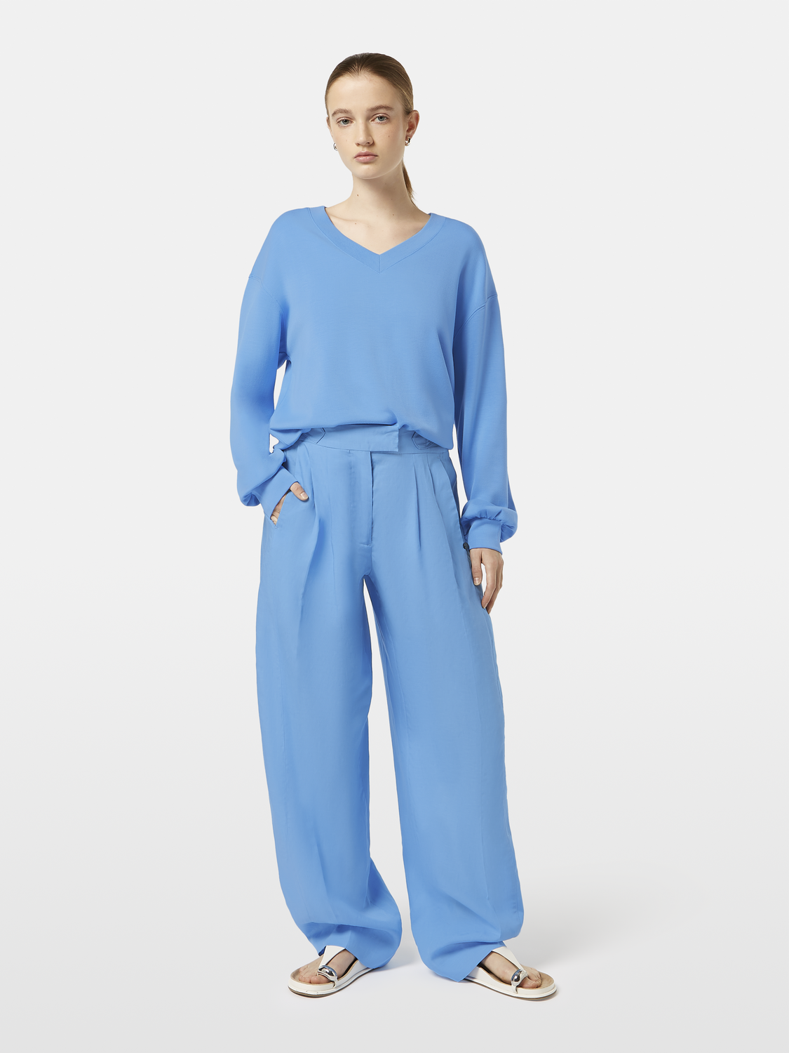 Scotch & Soda Quinn pleated pants in neutral fabric, tailored fit with pleats, front pockets, and belt loops, on a model.