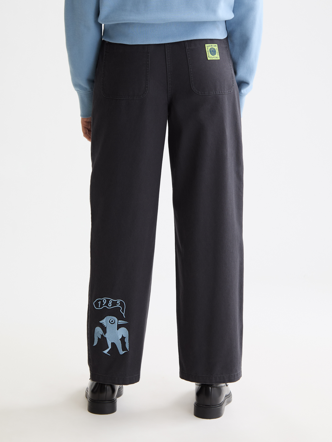 Scotch & Soda Raine wide-fit pants in dark fabric, shown from the back, featuring a relaxed fit and stylish design.