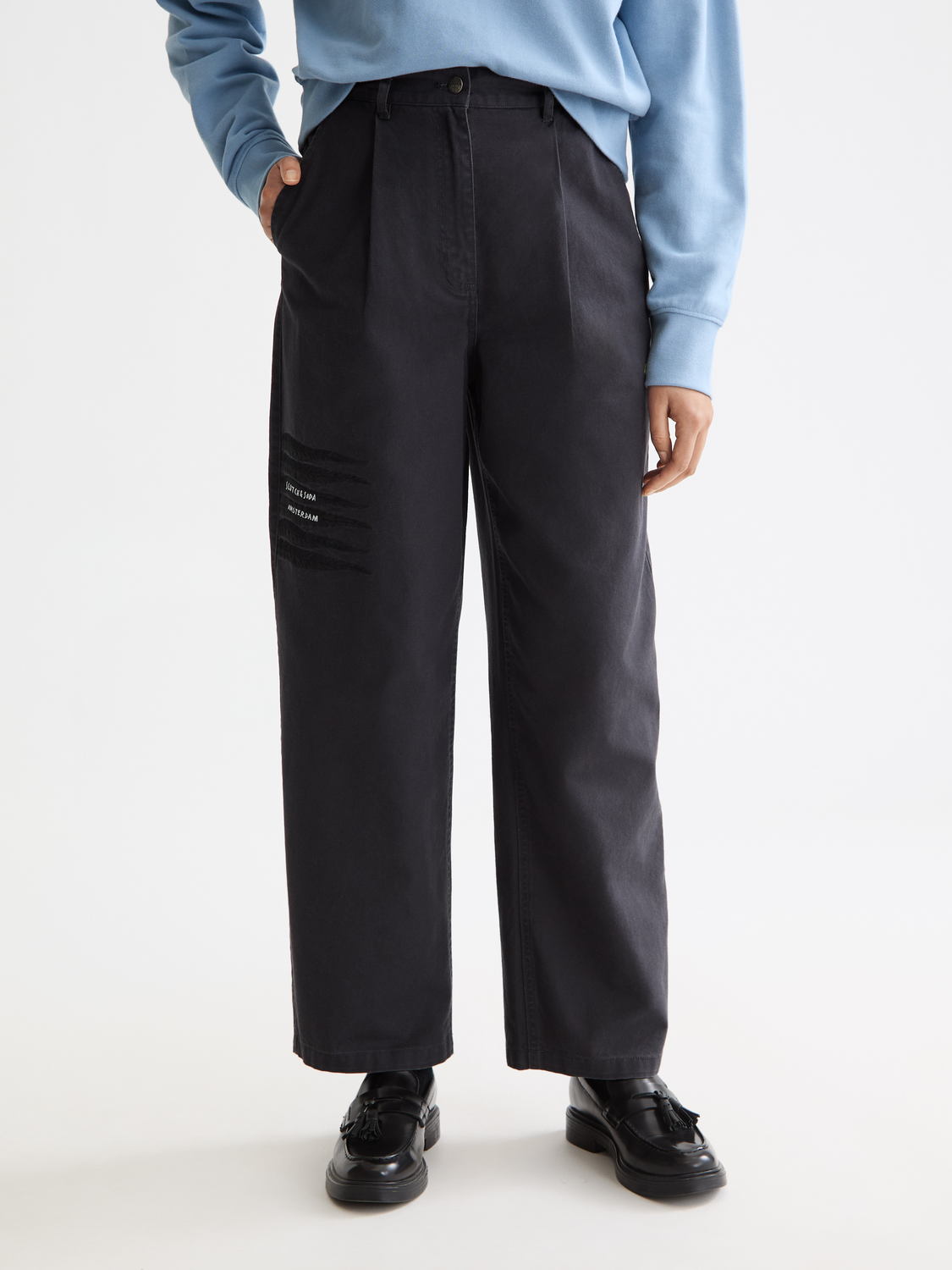 Wide-fit Scotch & Soda Raine pants in a light color, featuring a relaxed fit and tailored waistband, showcased on a model.