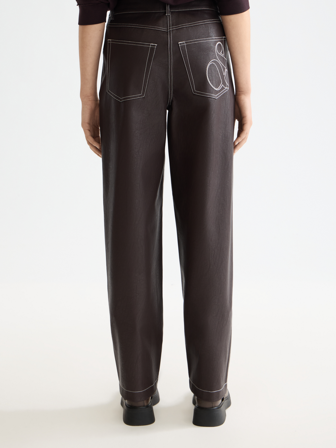 Black Aurora faux leather pants by Scotch & Soda, featuring a slim fit design on a model.
