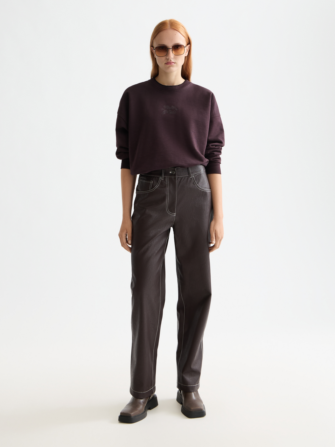Scotch & Soda Aurora faux leather pants showing a close-up of the black pants with sleek, fitted design and detailed stitching.