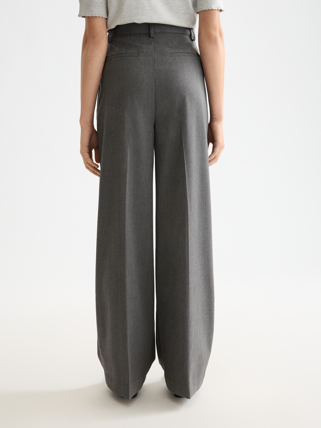 Wide-fit rose-colored pants by Scotch & Soda, showing the back view with relaxed fit and stylish design details.