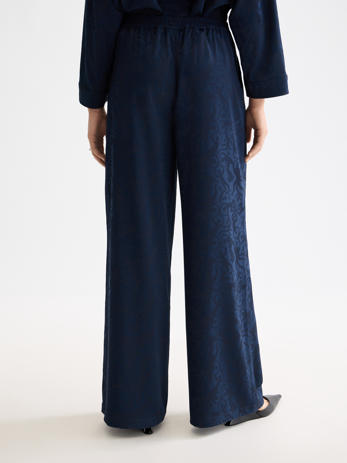 Black Eleni wide-fit pants by Scotch & Soda, featuring a relaxed fit and stylish design, shown on a model.