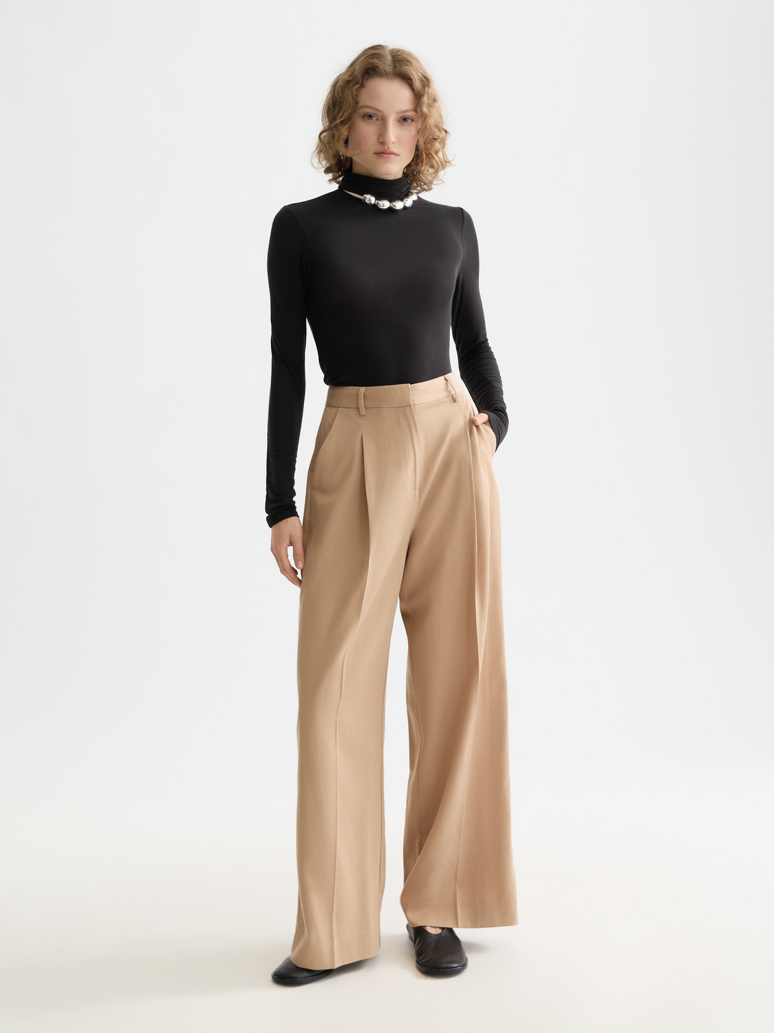 Wide-fit rose-colored pants by Scotch & Soda, featuring a relaxed fit and stylish design, shown on a model.