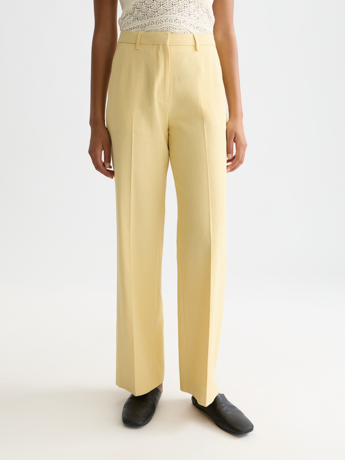 Wide-fit Edie pants by Scotch & Soda, featuring a relaxed silhouette in a soft cream color, shown on a model.