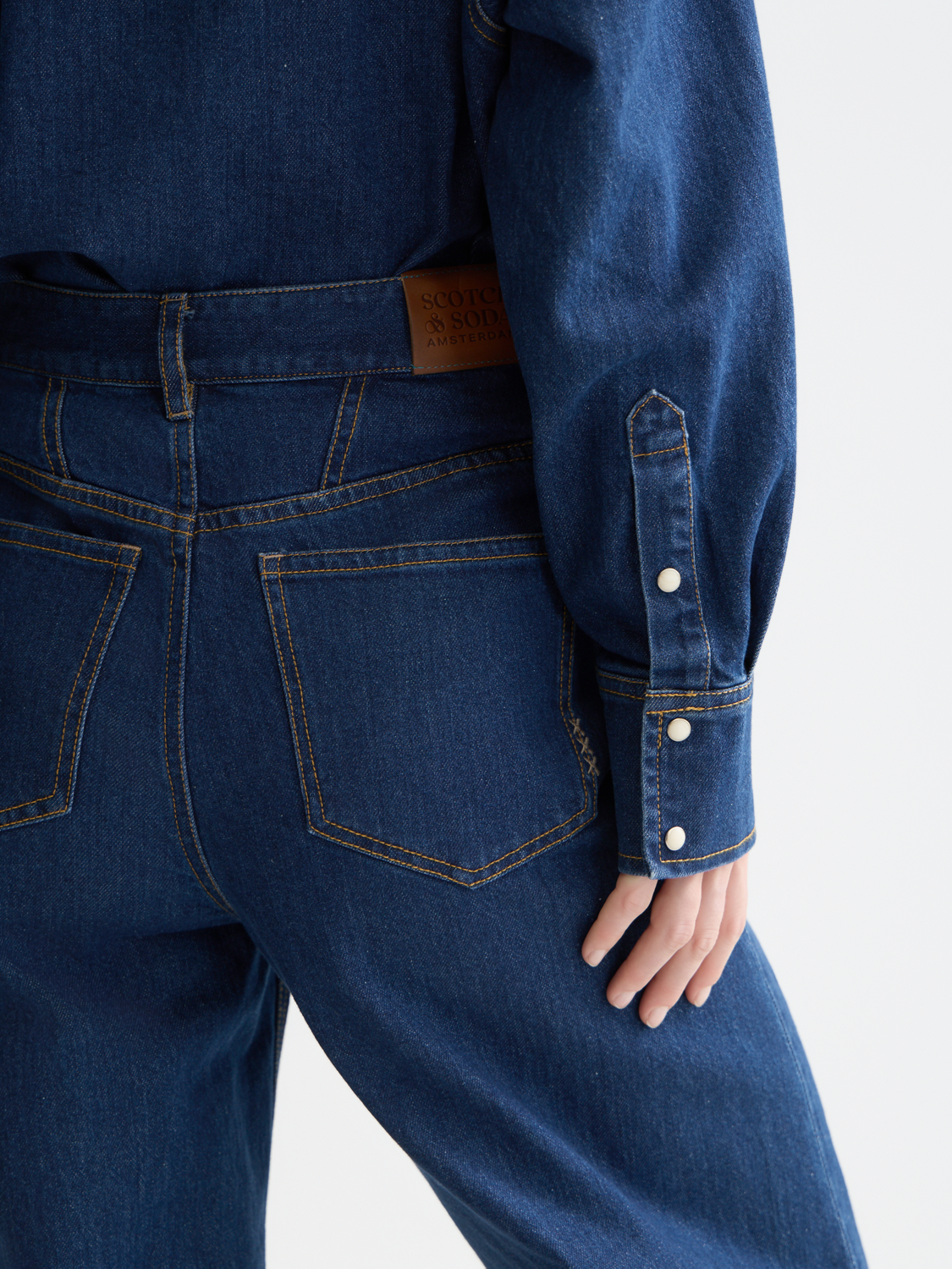 Blue denim Loop barrel leg jeans by Scotch & Soda, featuring a relaxed fit and classic five-pocket design.
