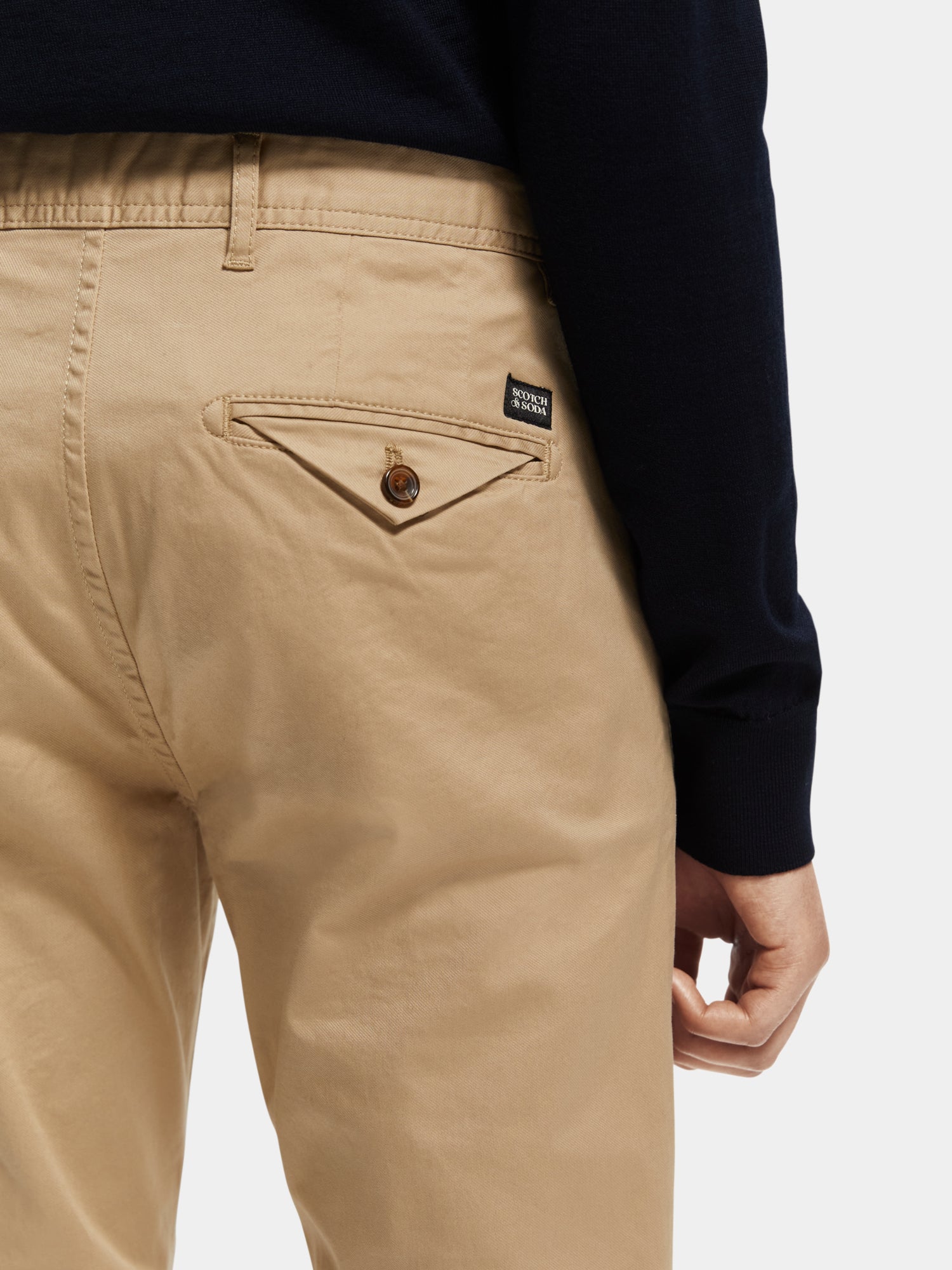 Slim fit Scotch & Soda Stuart chinos pants in a neutral color, shown on a model with a close-up of the fabric and fit.