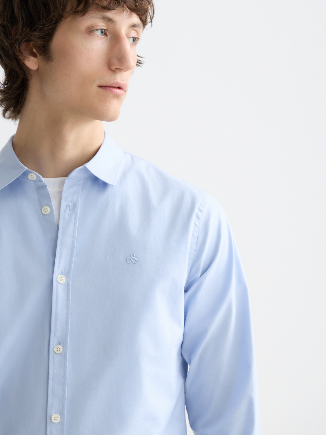 Long-sleeve Scotch & Soda poplin shirt displayed on a model, featuring a classic collar and button-front design.