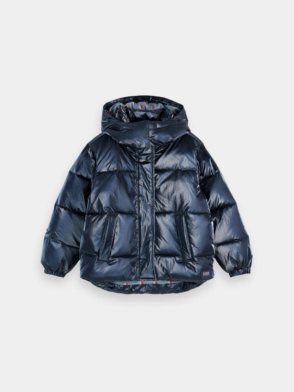 Kids metallic puffer jacket by Scotch & Soda, showing a shiny silver quilted jacket with a hood and front zipper.