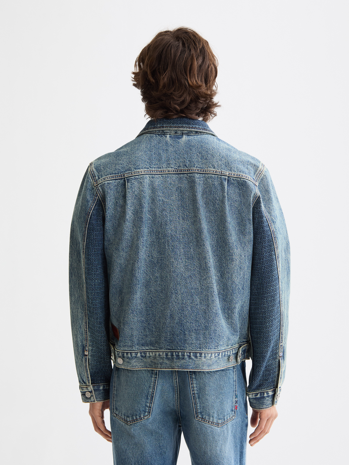 Scotch & Soda denim trucker jacket with button front, classic fit, and adjustable waist, shown from the back.