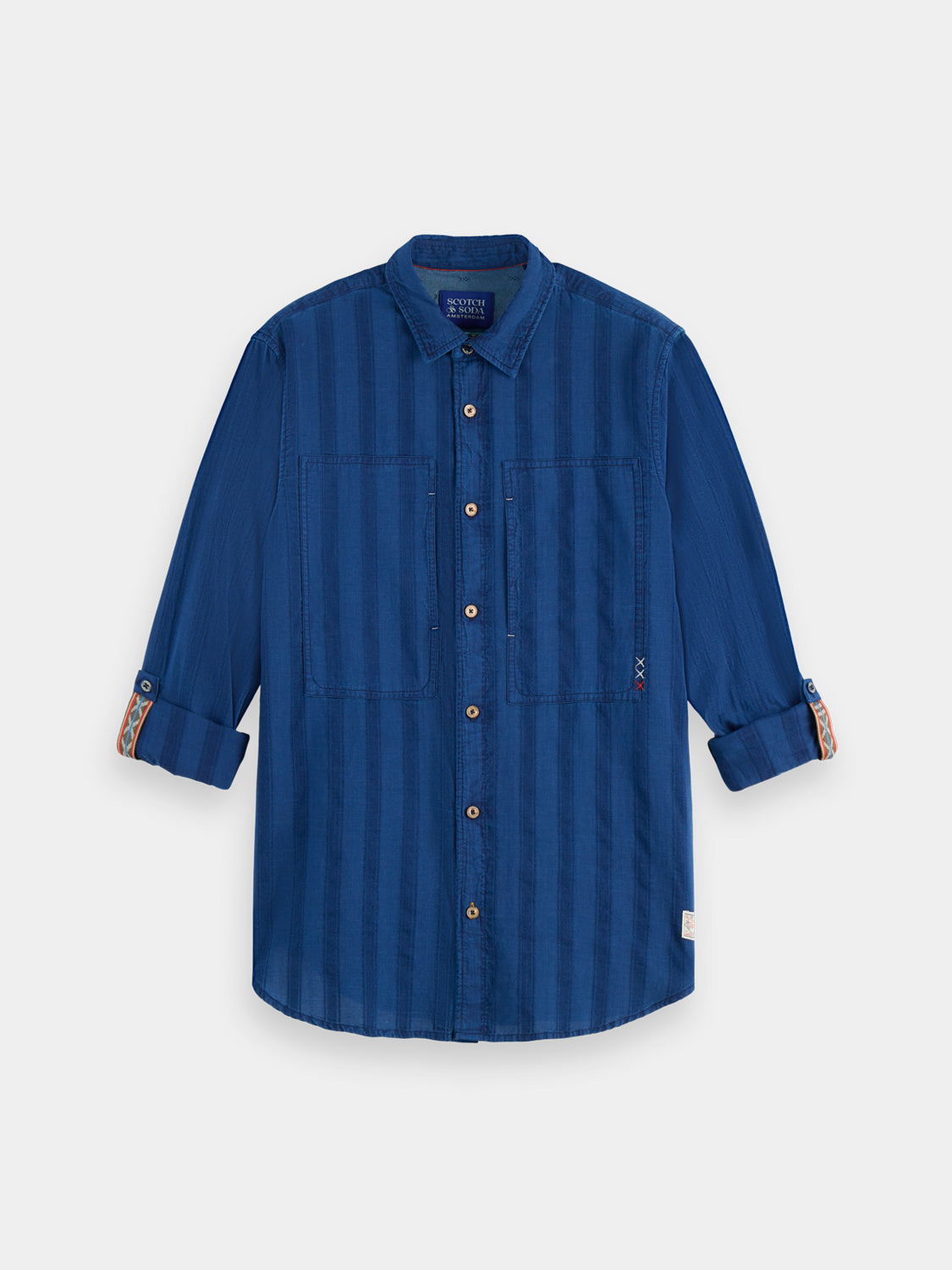 Textured indigo Scotch & Soda long-sleeve shirt with button collar and chest pocket, styled on a hanger.