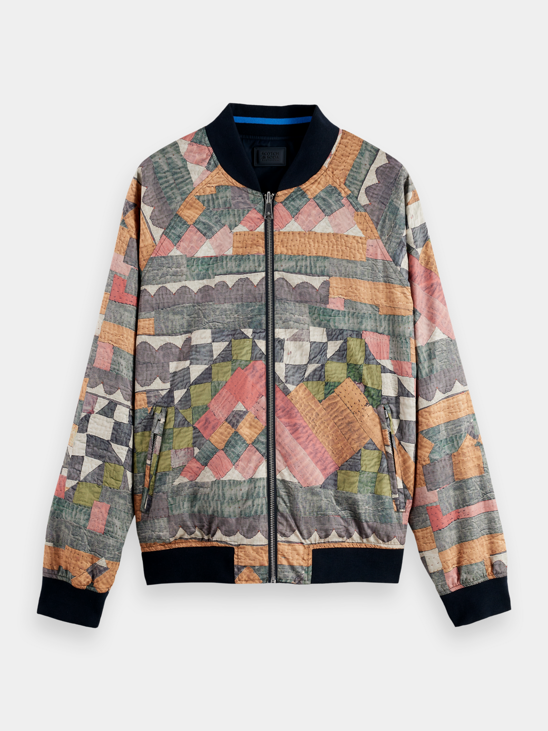 Reversible bomber jacket by Scotch & Soda, showing both solid and patterned sides, with a zip front and ribbed cuffs.