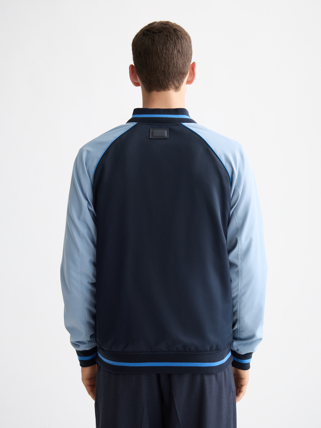 Reversible bomber jacket by Scotch & Soda featuring a stylish design, shown with both sides visible in the image.