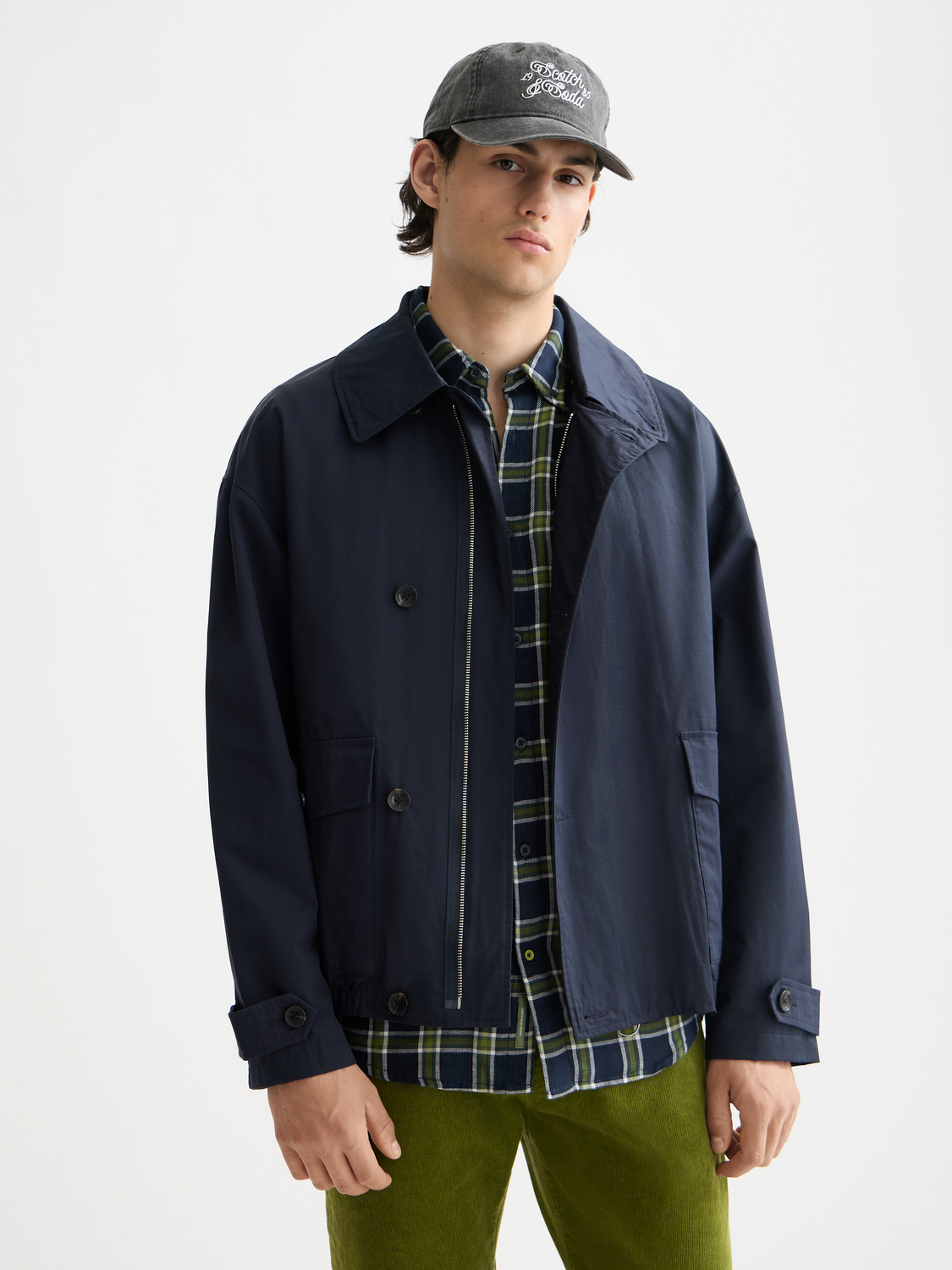 Light beige Scotch & Soda short trench coat with classic collar and button details, shown on a hanger.