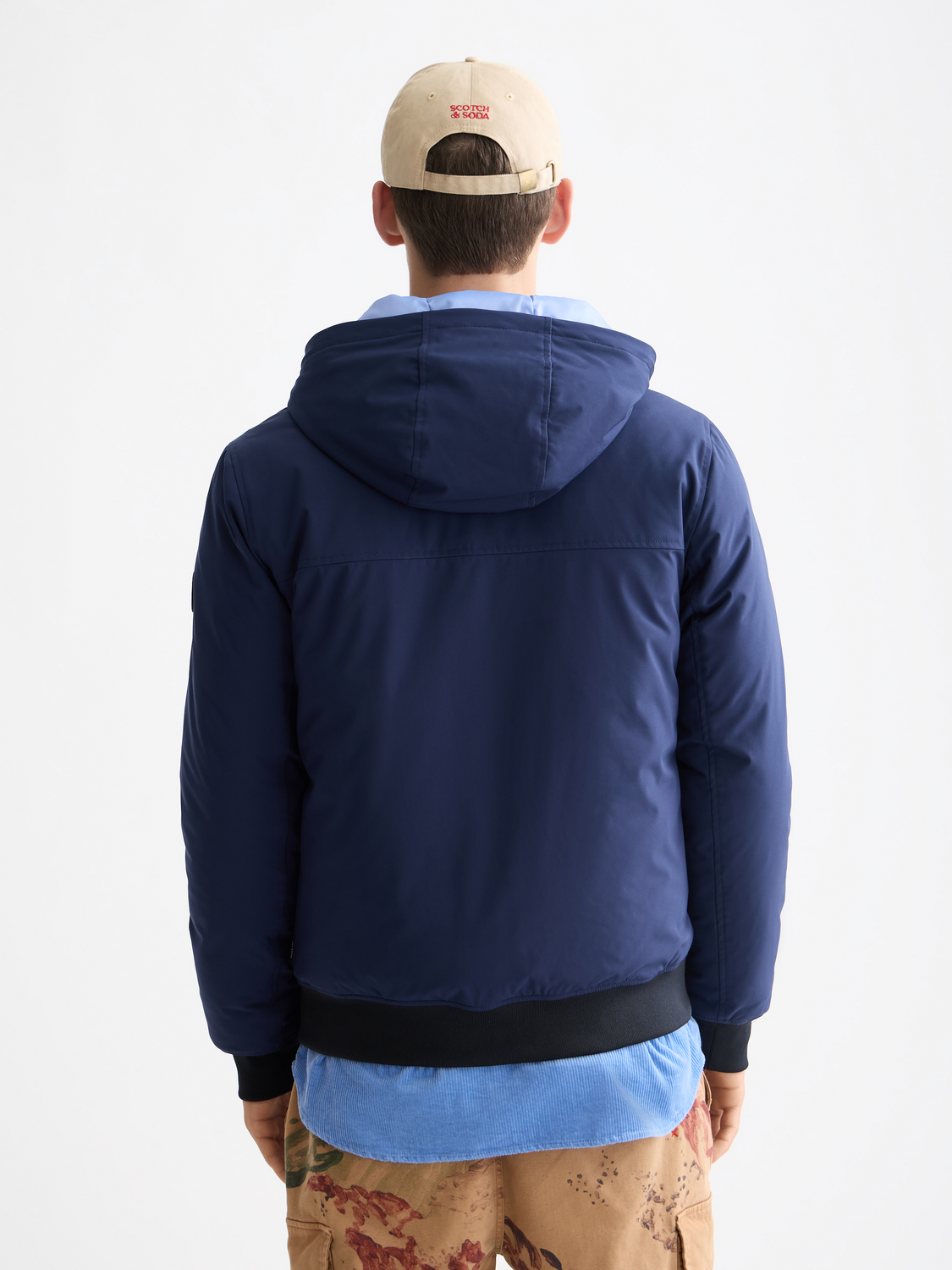 SCOTCH & SODA hooded softshell jacket with front zipper, adjustable hood, and side pockets, shown in black against a white background.
