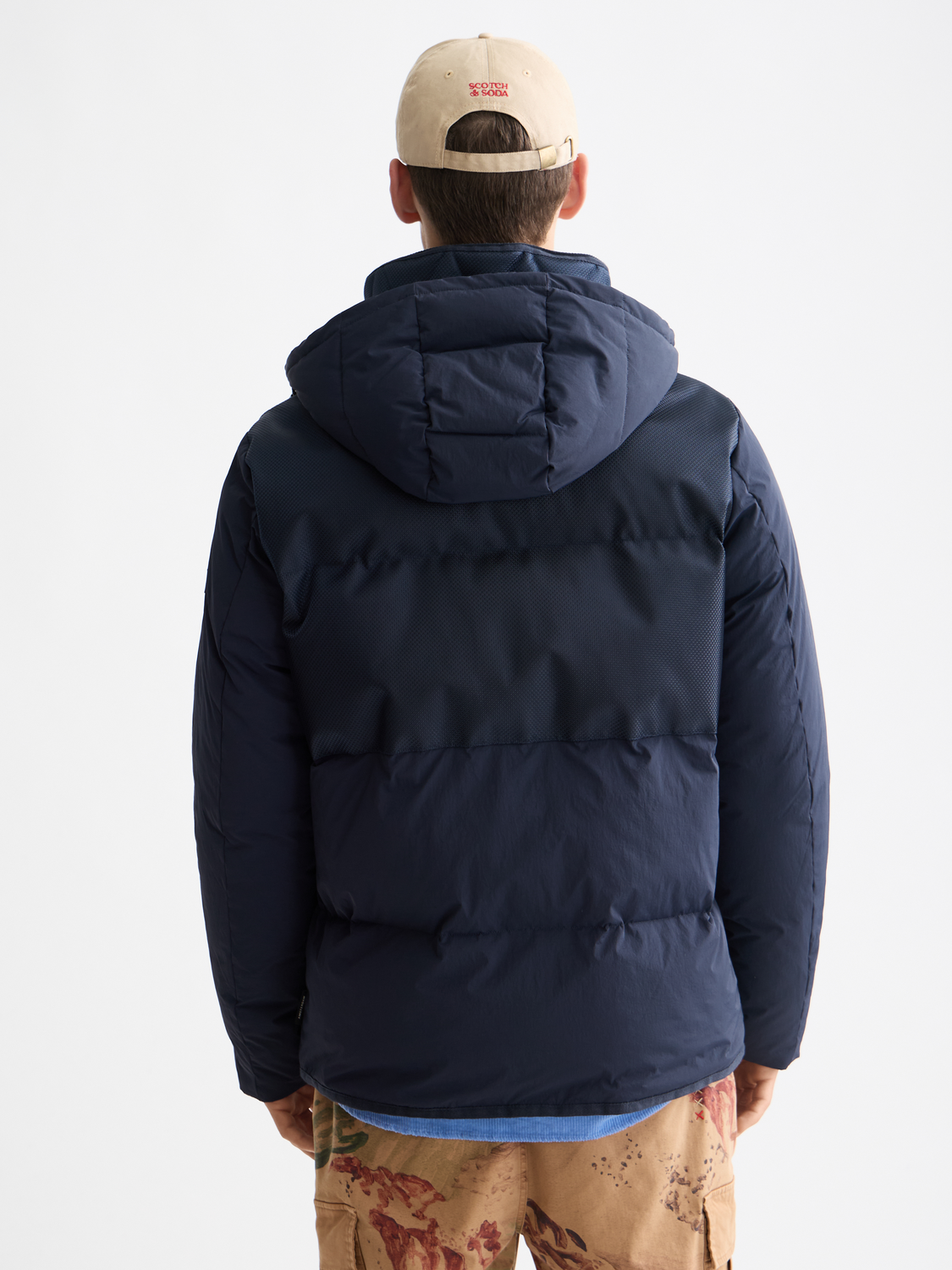 Scotch & Soda hooded puffer jacket in black with a quilted design and front zipper, suitable for cold weather.
