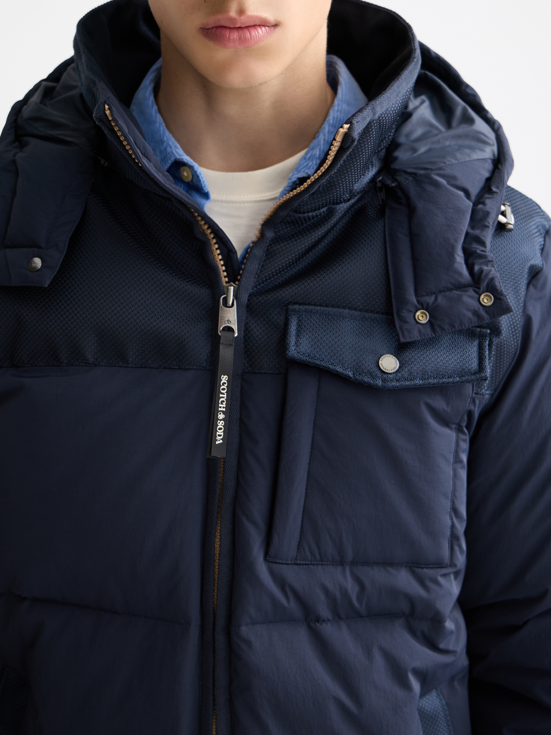 Scotch & Soda hooded puffer jacket with quilted design and front zipper, suitable for cold weather.